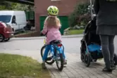Ein Kind fährt auf dem Gehweg Fahrrad
